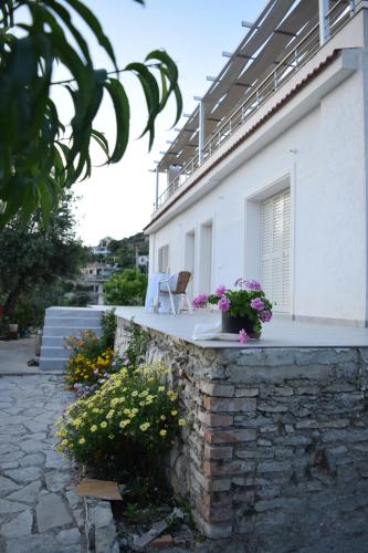 a white house with a chair on the balcony at Belvedere Adriatica in Qeparo