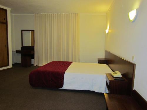a hotel room with a bed and a telephone at Sao Tomas in Fátima