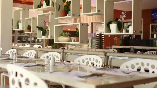 a dining room with tables and white chairs at Lyz Business Hotel in Lima