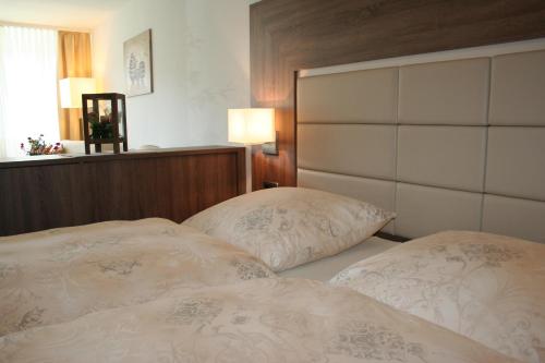 two twin beds in a bedroom with a headboard at Hotel Villa Undine in Grömitz