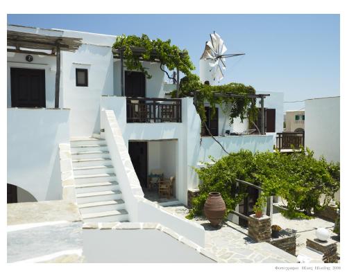 a white house with stairs and a windmill at Anemomilos Beach hotel in Agia Anna Naxos