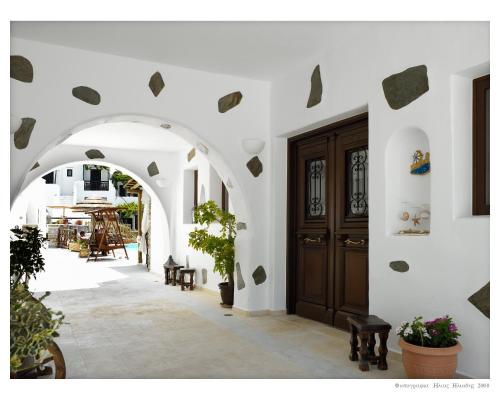 a hallway with an archway and a wooden door at Anemomilos Beach hotel in Agia Anna Naxos