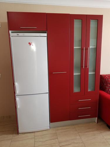 einen weißen Kühlschrank neben einem roten Schrank in der Unterkunft Apartament Pto Rosario 4PAX in Puerto del Rosario
