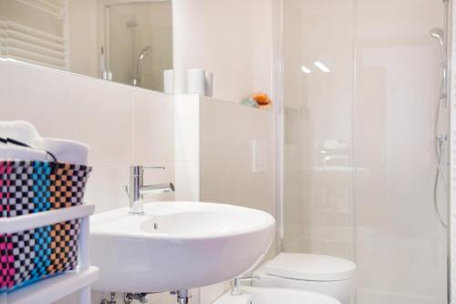 a bathroom with a sink and a toilet and a shower at Appartamenti Vistaqua in Baveno