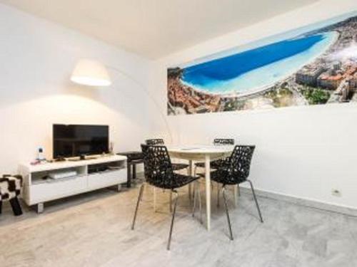 comedor con mesa, sillas y TV en Appartement 3 pièces SoNice au centre de Nice en Niza