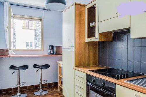 une cuisine avec deux tabourets devant un comptoir dans l'établissement Appartement 3 pièces SoNice au centre de Nice, à Nice