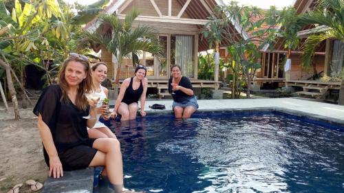 a group of people sitting in a pool at Tiki bar and more in Nusa Lembongan