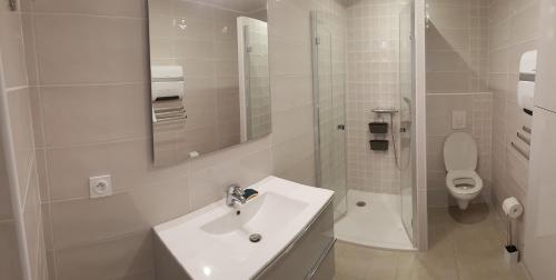 a white bathroom with a sink and a toilet at Boost Your Immo La Courtaude T3 N in Six-Fours-les-Plages