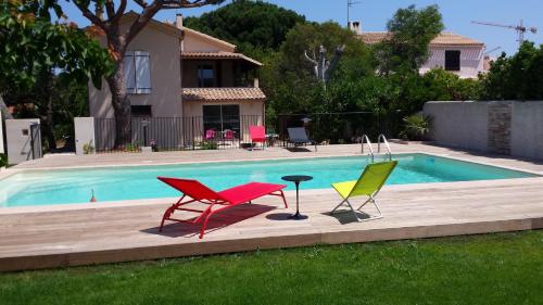 três cadeiras e uma mesa ao lado de uma piscina em Boost Your Immo La Courtaude T3 N em Six-Fours-les-Plages