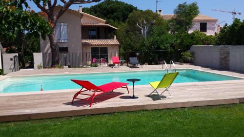 three chairs and a table next to a swimming pool at Boost Your Immo La Courtaude T3 N in Six-Fours-les-Plages