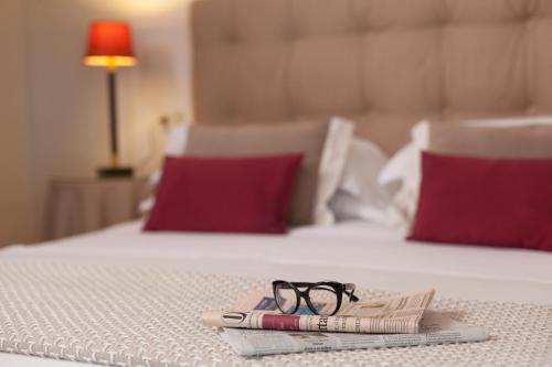 a pair of glasses and a magazine on a bed at Locanda I Girasoli in Misano Adriatico