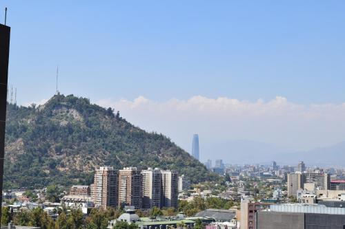 vistas a una ciudad con una montaña en el fondo en Santiago Furnished Apartments, en Santiago