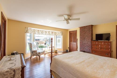 a bedroom with a bed and a dresser and a window at Chez Nous in Cornwall