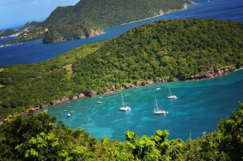 an island with boats in a body of water at Residence Hôteliere Hurlevent in Grande Anse