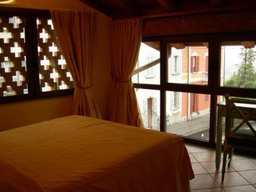 a bedroom with a bed and a large window at Locanda dell'Oca Bianca in Como