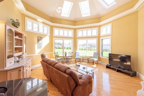 a living room with a couch and a tv at Chez Nous in Cornwall