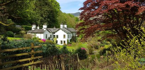 a white house in the middle of a garden at Foxghyll Country House in Ambleside