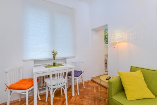 - un salon avec un canapé, une table et des chaises dans l'établissement The Charming Home - One Bedroom TOP Central Apartment, à Sofia