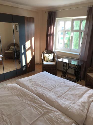 a bedroom with a bed and a chair and a window at Kranenbruch in Schwalmtal