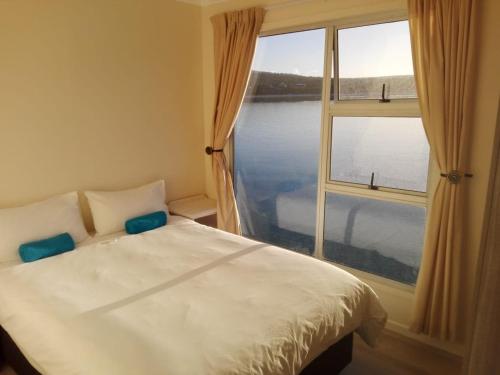 a bedroom with a bed and a large window at Kraalbaai Lifestyle House Boats in Langebaan