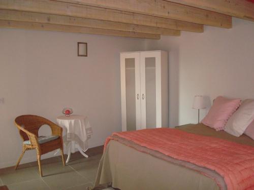 a bedroom with a bed and a table and a chair at Chambre d'hôtes Les Plaisances in Saint-Julien