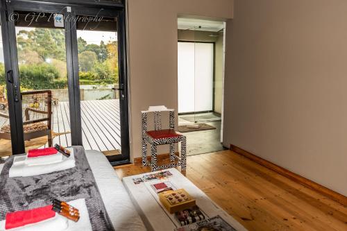 a living room with a couch and a balcony at Laguna Lodge in Graskop