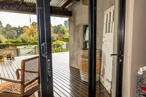 an open door to a patio with a barrel at Laguna Lodge in Graskop