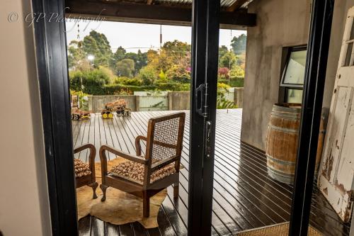 an open glass door with a chair on a porch at Laguna Lodge in Graskop