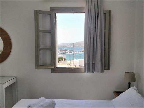 a bedroom with a window with a view of the ocean at Despina's Mare in Naousa