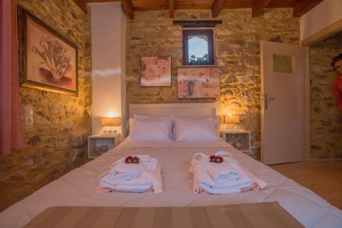 dwie kobiety w ręcznikami siedzą na łóżku w obiekcie Villa Kamelia-Renovated old house-South Crete w mieście Galiá