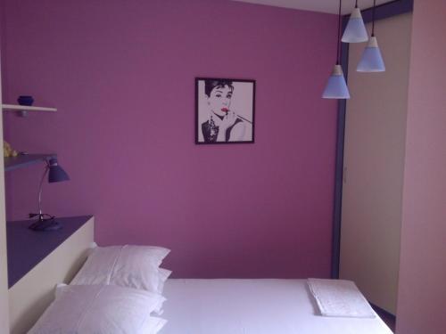 una camera da letto con una parete viola con la foto di un uomo di Pepermint a Baška Voda