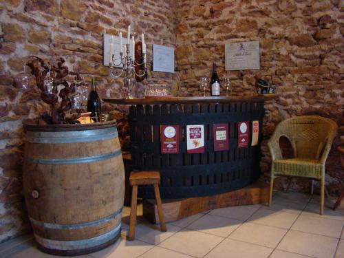 einen Weinkeller mit einem Fass, einem Tisch und einem Stuhl in der Unterkunft Chambre d'hôtes Les Plaisances in Saint-Julien