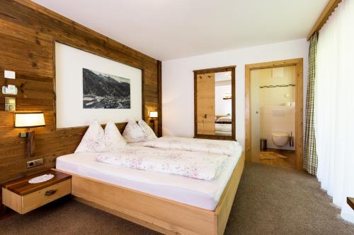a bedroom with a large bed in a room at Hotel Restaurant Rosmarie in Pfelders