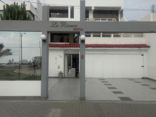 a building with a garage with a sign on it at Hostal La Rivera in Huanchaco
