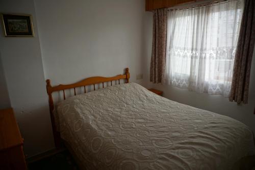 トレビエハにあるApartamentos Mar Azulのベッドルーム1室(ベッド1台付)、窓(カーテン付)