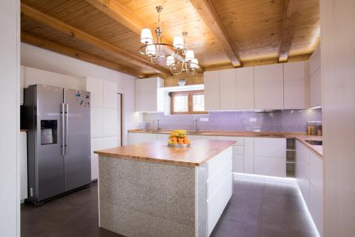 a kitchen with white cabinets and a wooden ceiling at Wellness Chata Brejlovka in Janov nad Nisou