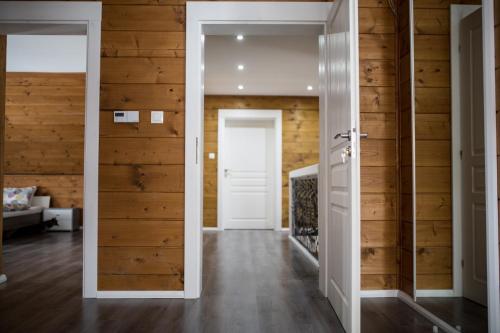 a hallway with wooden walls and a white door at Wellness Chata Brejlovka in Janov nad Nisou