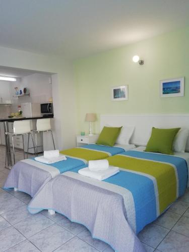 a room with three beds and a kitchen at Ocean Blue Apartments in Paphos
