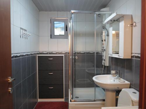 uma casa de banho com um chuveiro e um lavatório. em Apartment Sunrise em Sveti Stefan