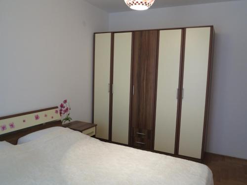 um quarto com uma cama e um grande armário de vidro em Apartment Sunrise em Sveti Stefan