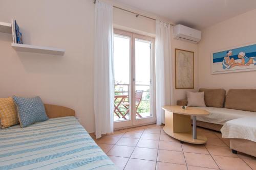 a room with a bed and a table and a window at Apartments Marta in Krk