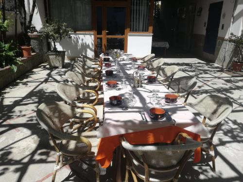 a long long table with chairs and plates on it at Hotel Gentile in Agerola