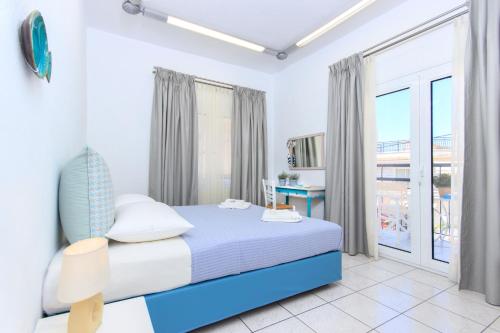 a bedroom with a bed and a large window at Agora Apartment in Limenas
