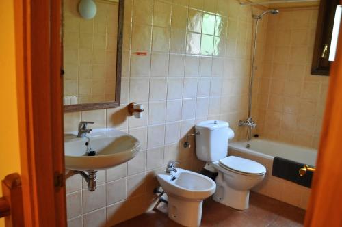 een badkamer met een wastafel, een toilet en een bad bij Can Simonet de Rocabruna in Rocabruna