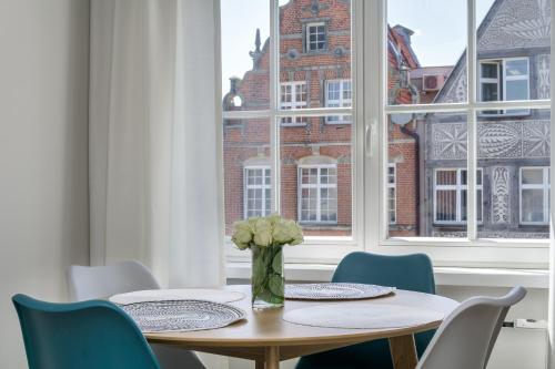 a dining room with a table and chairs and a window at Elite Apartments Heart of the Old Town in Gdańsk