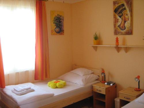 a small bedroom with a bed with fruit on it at Tó- Party Panoráma Panzió & Wellness in Kiszombor