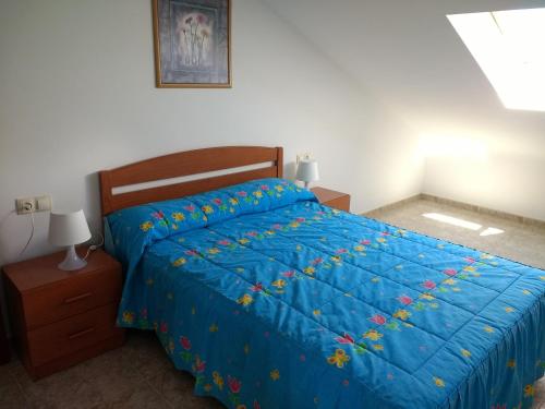 1 dormitorio con cama azul y edredón azul en ApartamentosFinisterre, en Finisterre