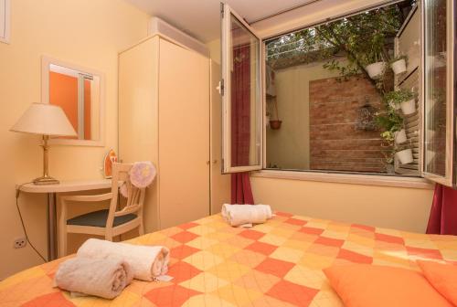 a bedroom with a bed and a window and a desk at Studios Lulic in Makarska