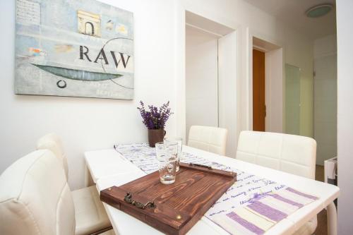 a dining room table with a wooden tray on it at Apartmani Luka in Vir
