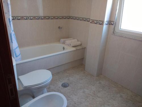 a bathroom with a toilet and a tub and a sink at ApartamentosFinisterre in Finisterre